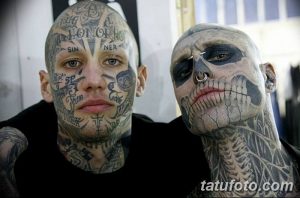 Фото тату: два мужчины с полными татуировками на лицах и шеях, смотрящие в камеру, демонстрирующие сложные узоры и символы.
